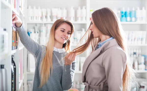 Asistente Tienda Belleza Eligiendo Cosméticos Para Cuidado Del Cabello Con —  Fotos de Stock