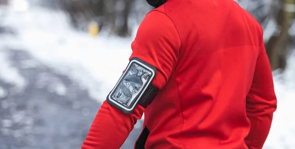Fitness phone armband on warm sporty running clothes during winter exercise outdoor