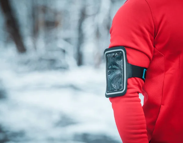 Fitness phone armband on warm sporty running clothes during winter exercise outdoor