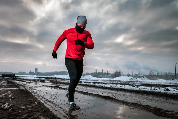 Runner man running in dirty puddle at winter, outdoor exercise — Stock Photo, Image