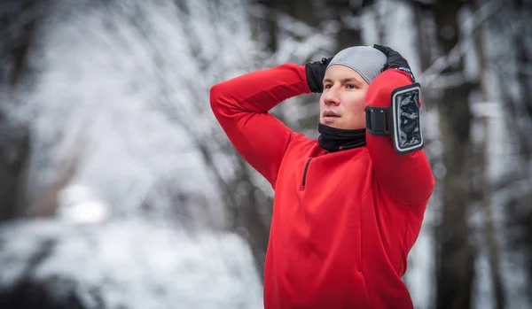 Winter running exercise, runner wearing warm clothes has break