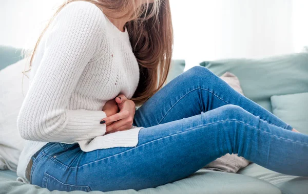 Young Woman Suffering Abdominal Pain While Sitting Sofa Home — Stock Photo, Image