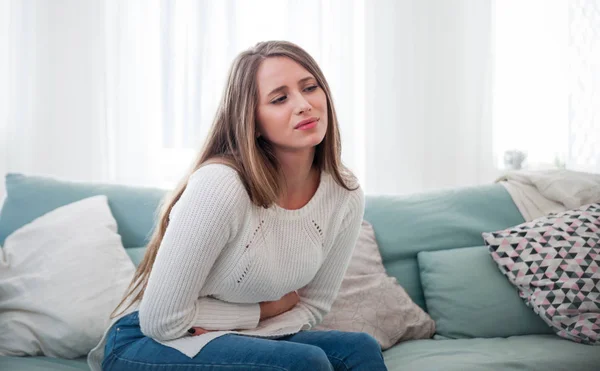 Young Woman Suffering Abdominal Pain While Sitting Sofa Home — Stock Photo, Image