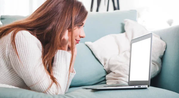 Vertrouwen vrouw thuis op de bank liggen en werken met laptop — Stockfoto