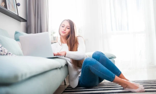 Mujer en casa con ordenador portátil en el sofá y el descanso —  Fotos de Stock