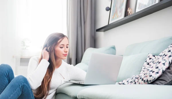 Donna a casa con computer portatile sul divano e riposo — Foto Stock