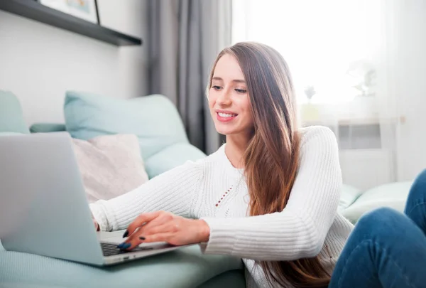 Frau zu Hause mit Laptop auf Sofa und Ruhesitz — Stockfoto