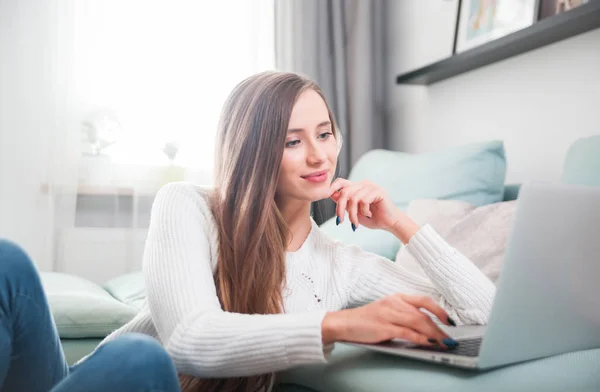 Nő otthon laptop számítógép használata a kanapé és pihenő — Stock Fotó
