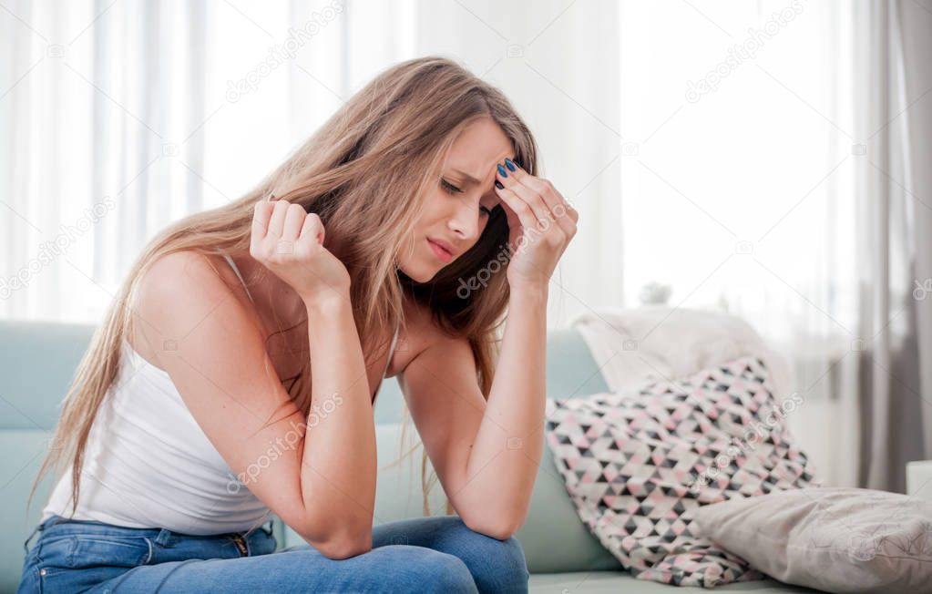 Woman at home suffering from headache, emotions and stress