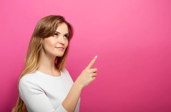Vrouw op roze achtergrond weergeven iets en ruimte bieden, kopiëren — Stockfoto