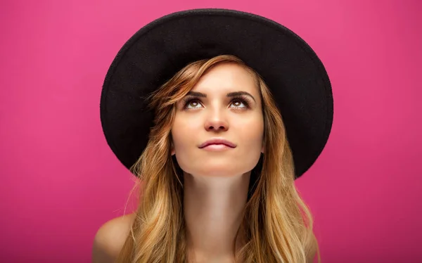 Beautiful young woman with hat and long blonde hair on pink back — Stock Photo, Image