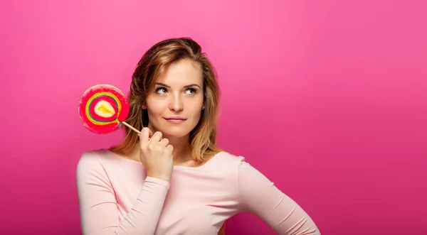Beautiful young woman with big lollipop on pink background, copy space — Stock Photo, Image