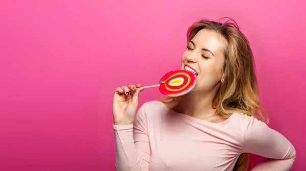 Beautiful young woman with big lollipop on pink background — Stock Photo, Image