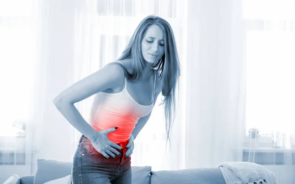 Jeune femme à la maison souffrant de douleurs abdominales — Photo