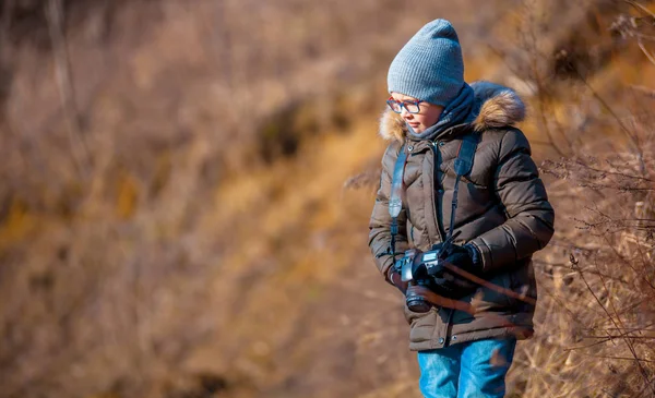 Chlapec s digitálním fotoaparátem, procházky do přírody, hobby koncepce — Stock fotografie