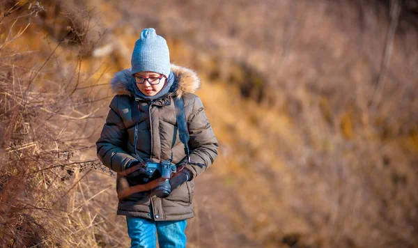 Chlapec s digitálním fotoaparátem, procházky do přírody, hobby koncepce — Stock fotografie