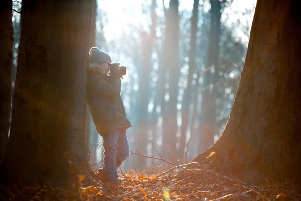 Мальчик с помощью цифровой камеры, фотографирующей на природе, хобби-концепция — стоковое фото