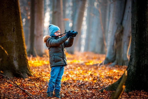 Chłopiec przy użyciu aparatu cyfrowego biorąc zdjęcie w przyrodzie, koncepcja hobby — Zdjęcie stockowe