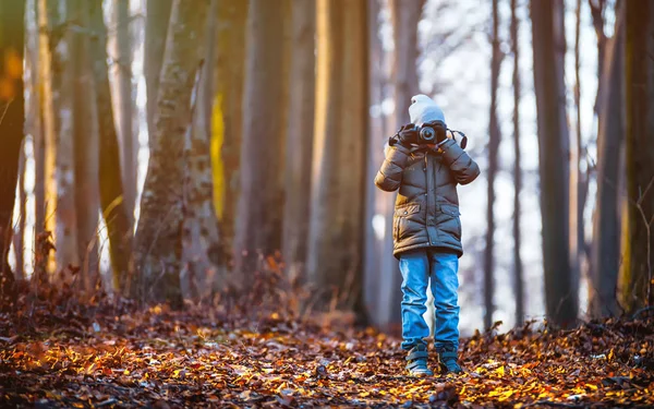Мальчик с помощью цифровой камеры, фотографирующей на природе, хобби-концепция — стоковое фото