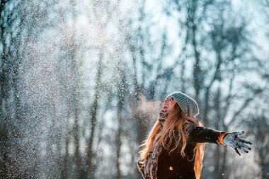 Gülümseyen genç kadın güneşli kış günü kar hava atma