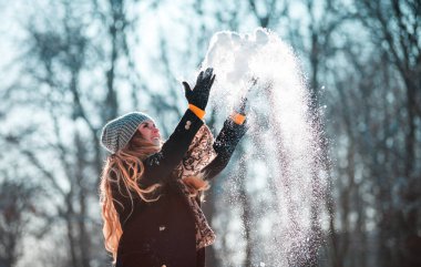 Gülümseyen genç kadın güneşli kış günü kar hava atma