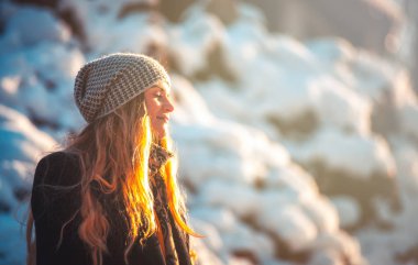 Güneşli bir gün, kış parkta yürüyüş sırasında genç kadın