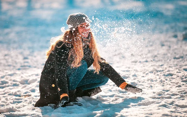 Úsměvem Mladá Žena Házení Sněhu Vzduchu Slunný Zimní Den — Stock fotografie