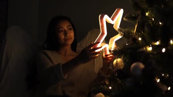 Jong Aziatische Vrouw Buurt Van Kerstboom Holding Ster Licht Decoratie — Stockvideo