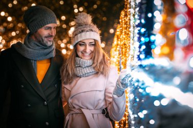 Sokakta Noel süslemeleri arasında yürürken sevgi dolu bir çift