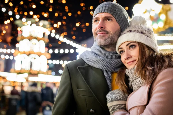 Liebespaar besucht abends den geschmückten Weihnachtsmarkt — Stockfoto