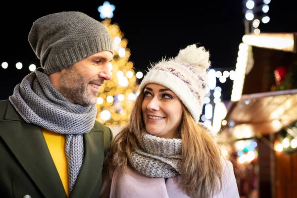 Liebespaar besucht abends den geschmückten Weihnachtsmarkt — Stockfoto