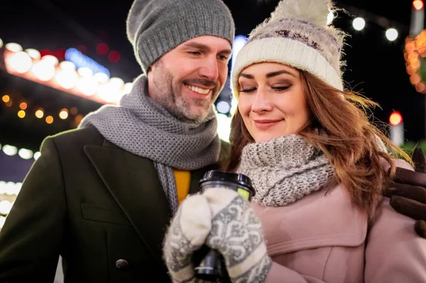 Retrato de um casal amoroso entre decorações de rua de Natal durante as férias de inverno — Fotografia de Stock