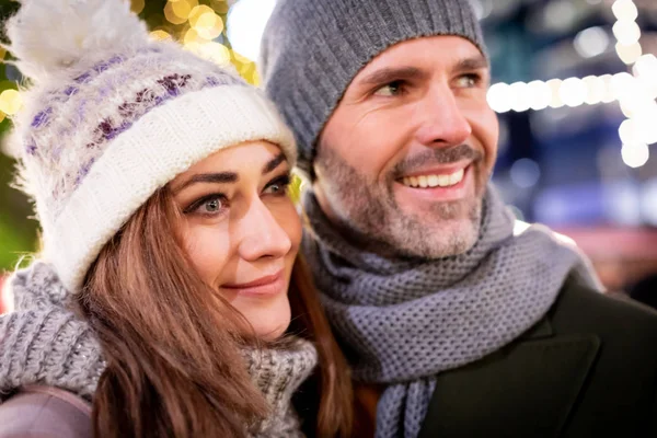 Portret kochającej pary wśród świątecznych dekoracji ulicznych podczas ferii zimowych — Zdjęcie stockowe