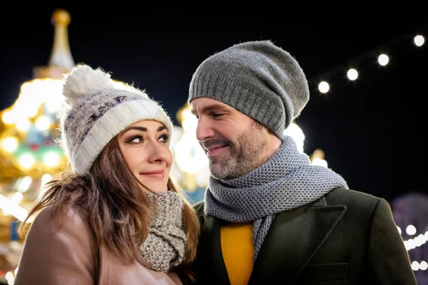 Portrait d'un couple amoureux parmi les décorations de rue de Noël pendant les vacances d'hiver — Photo