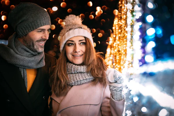 Liebespaar beim Spaziergang zwischen Weihnachtsdekoration auf der Straße — Stockfoto