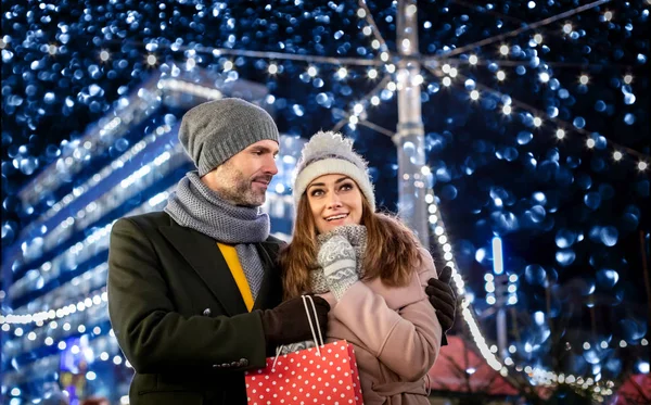 Liebespaar vor dem Hintergrund der Winterfestdekoration bei einem Abendspaziergang rund um den Weihnachtsmarkt — Stockfoto