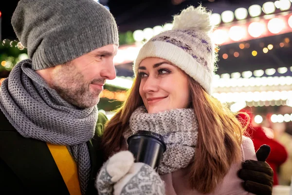 Liebespaar vor dem Hintergrund der Winterfestdekoration bei einem Abendspaziergang rund um den Weihnachtsmarkt — Stockfoto