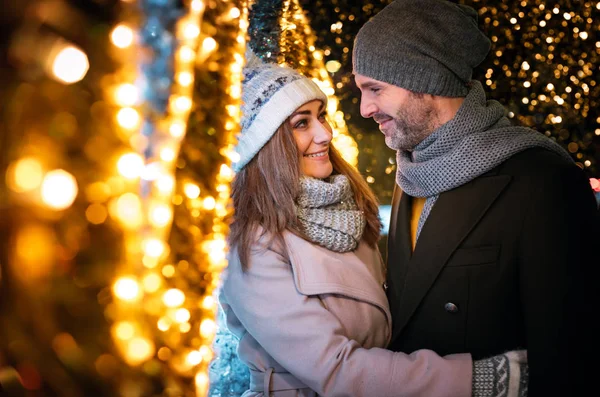 Aimer les câlins de couple parmi les décorations de Noël rue — Photo