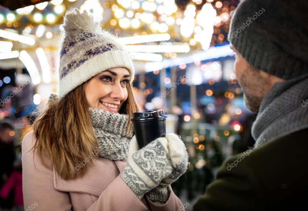 The couple spends the evening at a Christmas market full of light decorations