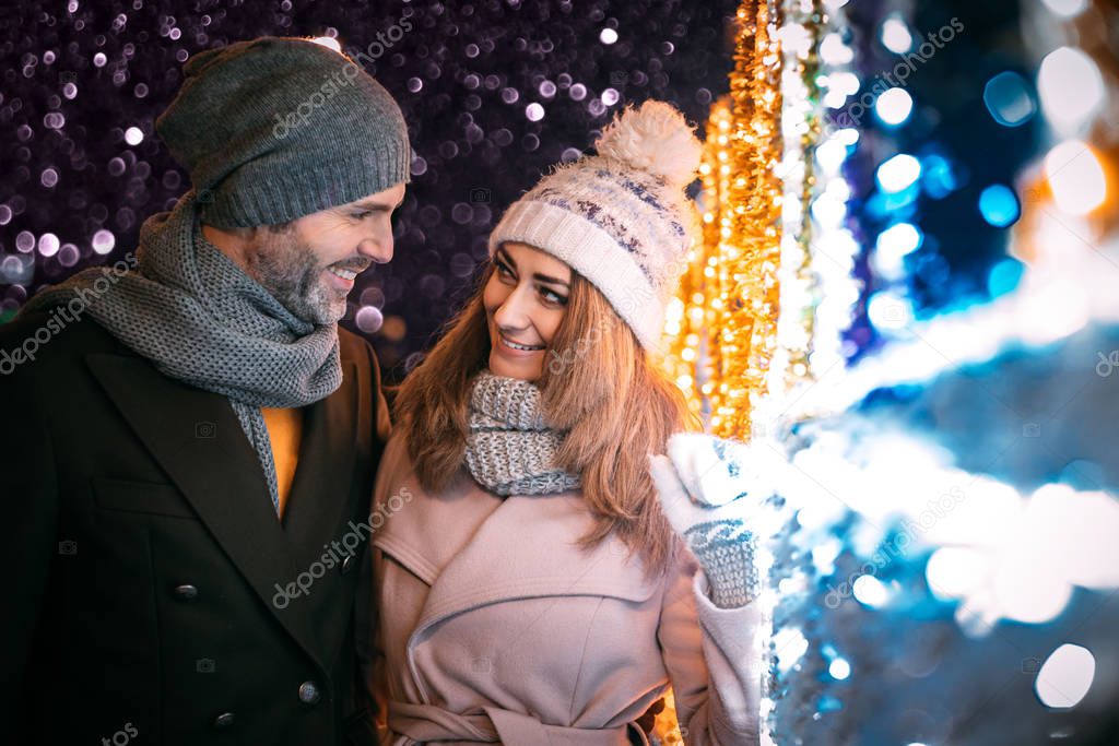 Happy couple walks on a street decorated for Christmas