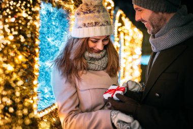 Piyasada dolaşırken süslemeler arasında bir Noel hediyesi vermek