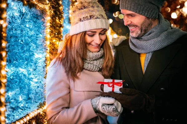 Weihnachtsgeschenk inmitten von Dekorationen beim Bummel über den Markt — Stockfoto