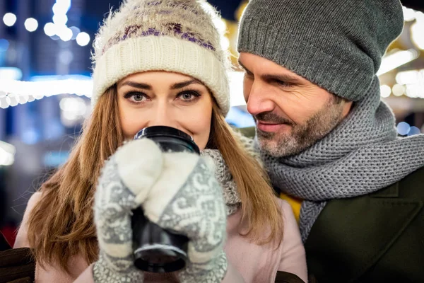 Roztomilý pár tráví čas spolu na vánočním trhu pití horké kávy — Stock fotografie