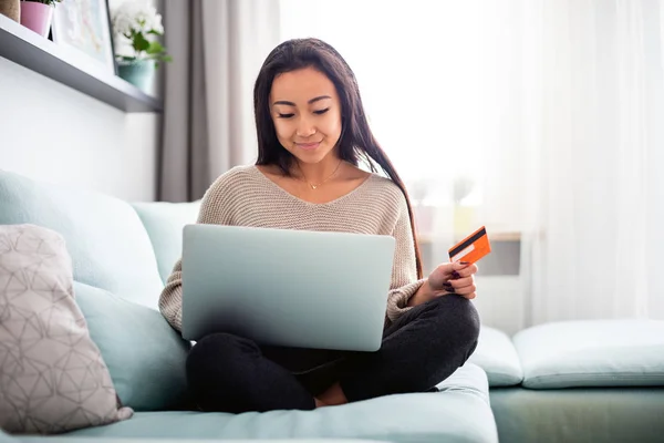 Азійська дівчинка робить онлайн-оплату за допомогою ноутбука для покупки вдома. — стокове фото