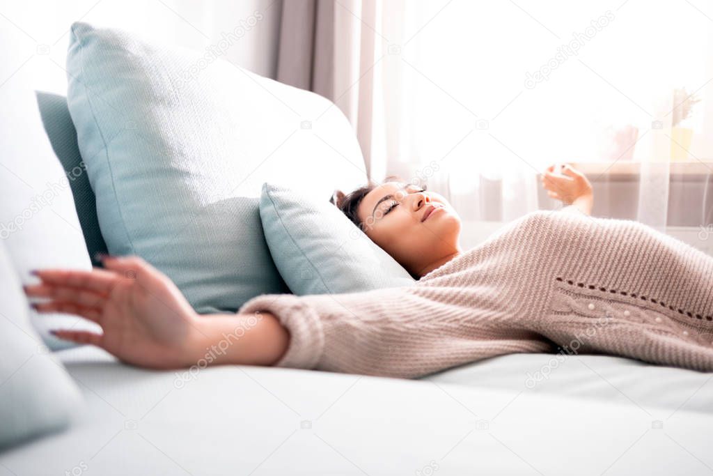 Leisure time at home, asian woman in positive mood relaxing on sofa