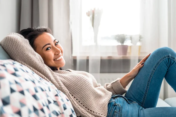 Entspanntes asiatisches Mädchen liegt in ruhiger Freizeit zu Hause auf dem Sofa — Stockfoto