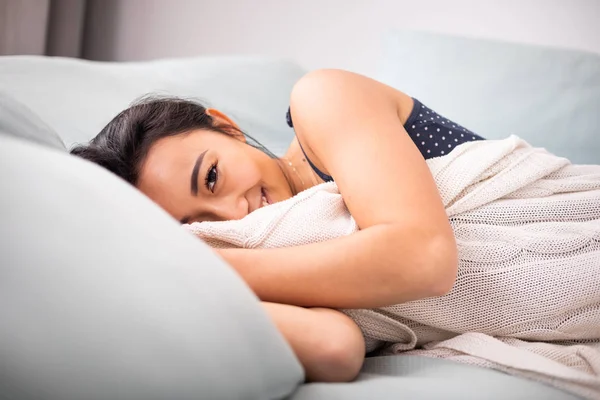 Расслабленная азиатская молодая женщина лежит в постели дома — стоковое фото