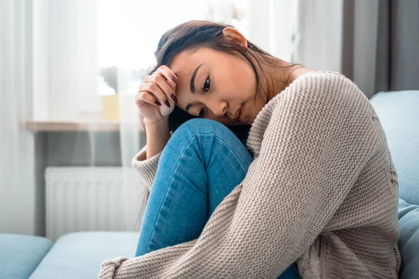 Droevige eenzame depressieve aziatische vrouw op de bank thuis — Stockfoto