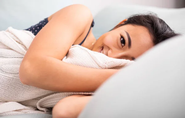 Lächelnde asiatische junge Frau liegt zu Hause im Bett — Stockfoto