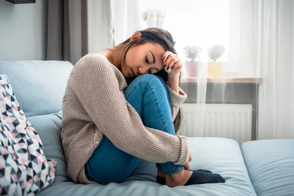 Unhappy lonely depressed asian woman on sofa at home — Stock Photo, Image